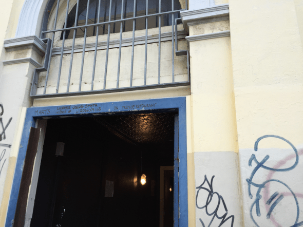 Turn in when you see the bouncer and the sketchy blue entrance way